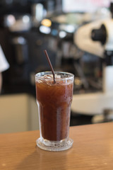 Iced Americano coffee.Background with coffee machine and barista.
