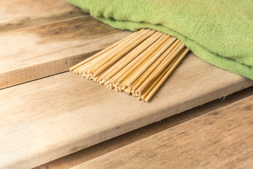 Bamboo broom lies under a green towel in a bath