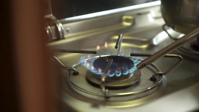 Slowmo close up - Lighting up gas stover burner fire and a pot in a campervan