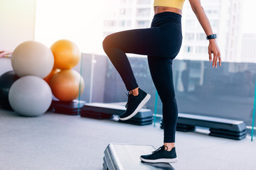 Obraz premium Close up low section of young woman doing aerobics. Fresh female fitness model at gym with copy space