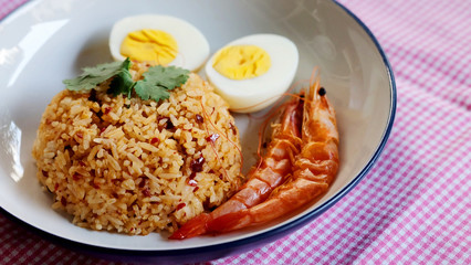 Thai chili paste fried rice, boiled egg and sweet shrimp on white plate and space for write wording, easy cook meal for home making or served in restaurant, popular for foreigner or tourist