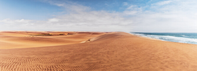 Panoramic Photograph of dunes and ocean on Namibe desert. Africa. Angola. - obrazy, fototapety, plakaty