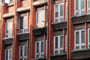 Line of windows separated by red bricks.