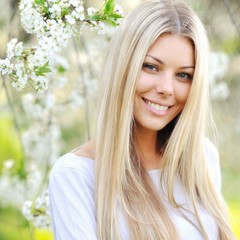 Naklejka premium Beautiful girl in a blooming garden in spring - cloe up portrait