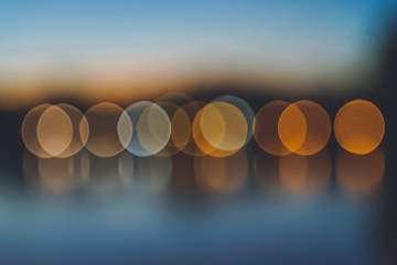 Sunset twilight round shape blurred bokeh reflection river front, abstract background