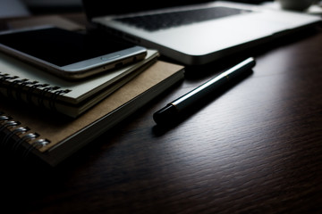 Close up office desk table with laptop, note book, mobile coffee and pen. Selective focus. Business concept. Copy space.