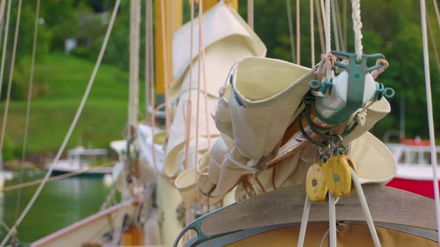 Sailboat rigging and folded sail bobbing in the water while the boat is moored in harbor. Nice establishing shot for Maine or New England travel video