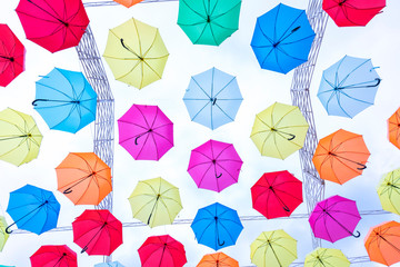 Colorful umbrellas hung in the sunny sky. Street decoration in tourist areas to attract visitors