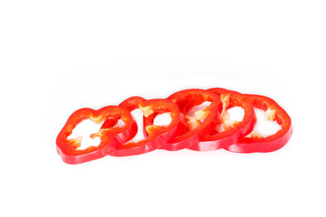 red bell pepper cut into pieces on white background.