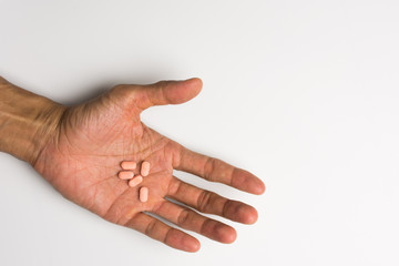 Medicine or pill in hand on white background,soft focus.