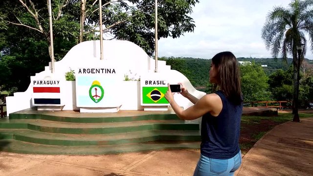 Behind woman taking photograph on smartphone. Argentine Tres Frontera