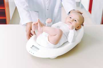doctor weighting cute baby at home