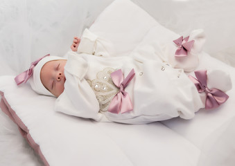 sleeping newborn baby in a wrap lying on a warm blanket