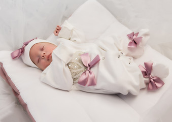 Fototapeta na wymiar sleeping newborn baby in a wrap lying on a warm blanket