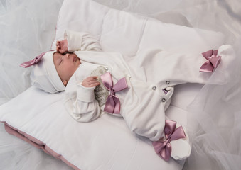 Obraz na płótnie Canvas sleeping newborn baby in a wrap lying on a warm blanket