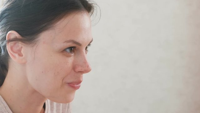 A woman eating something and smiling. Face close-up.