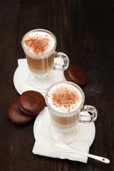 Cappuccino with cinnamon. Cup of coffee on wooden background