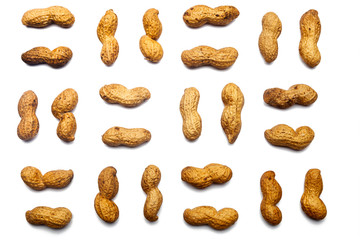 A collection of  unpeeled peanuts lie in horizontal rows on an isolated white background. with clipping path.  Unpeeled peanuts pattern