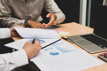 Start up business. people team work meeting point to discuss the graph up and down of economy and work on table.