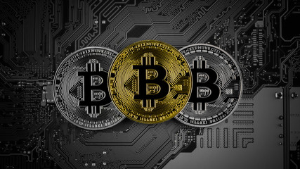 golden and silver bitcoins on circuit board.