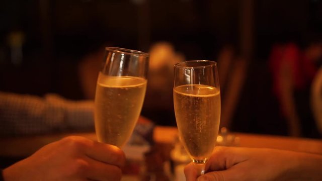 Couple in luxury restaurant cheers with glasses of champagne