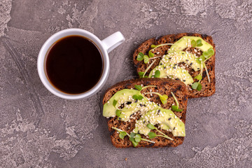 Tasty rye toasts with avocado, radish sprouts and sesame