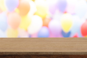 Perspective empty white wooden table on top over blur balloon background, can be used mock up for montage products display or design layout.