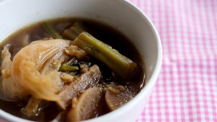 Chinese vegetable soup in white bowl on pink background and space for write wording, traditional low cost Chinese food from many kinds of vegetable and pork, served in Thai or Chinese restaurant