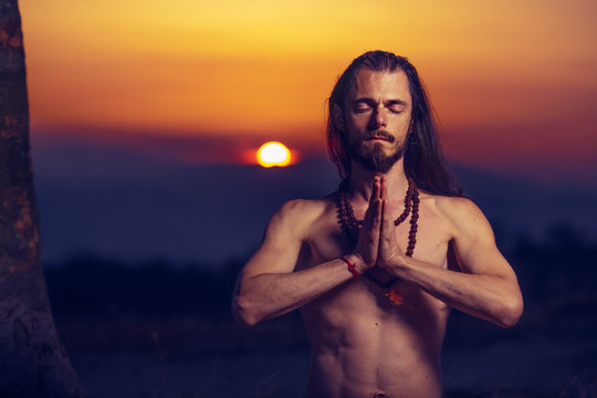 Yogi man meditating at sunset on the hills. Lifestyle relaxation emotional concept spirituality harmony with nature