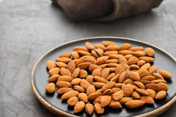 Assorted nuts in bowls on a black background. Copy space.