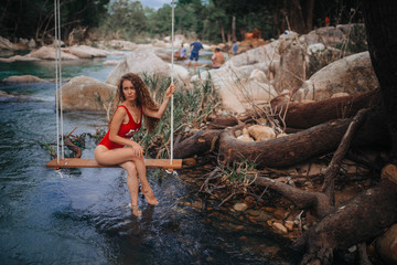 girl at the mountain river on a swing