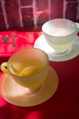 Cups of tea on red table