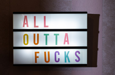 Message All Outta Fucks on illuminated board. Careless and empathy concept with text.