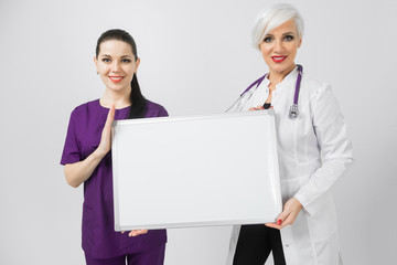 Doctor and nurse holding an empty magnetic Board isolated on white background