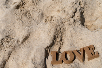 Fototapeta premium 3D Letters of LOVE on the sand background