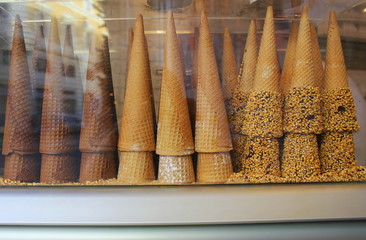 A pile of waffle cones for ice cream ready to be filled with ice cream in a cafe, restaurant. Showcase of a cafe, a pastry shop, a restaurant