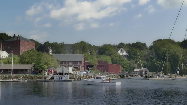 Lobster boat comes into port at scenic New England fishing village harbor &permil;&Ucirc;&Oacute;  in slow motion - wide shot - no markings on the boat