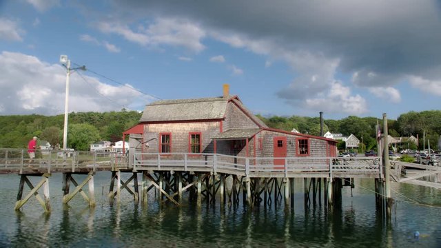 Clam shack located on a pier in Boothbay Harbor, Maine on a nice summer day with beautiful clouds in the sky.