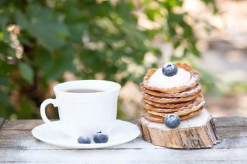 A stack of delicious pancakes with honey and blueberries on a wood background. with copy space