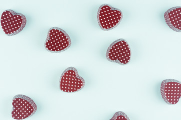 Valentine's day abstract background - brown chocolate candy hearts on light mint background as decorative pattern, top view.