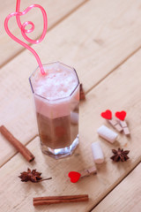 Coffee with milk in a glass with a pink tube.