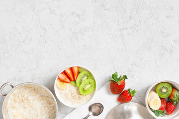 Background with oatmeal porridge and fresh fruits on the white table