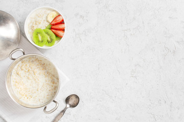 Background with oatmeal porridge and fresh fruits on the white table