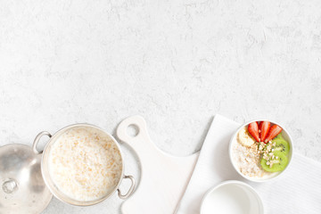 Obraz na płótnie Canvas Background with oatmeal porridge and fresh fruits on the white table