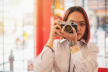 women photographer hand holding retro camera.