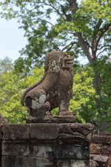 Fototapeta na wymiar Stone lion covered in lichen guards steps