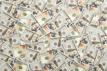 A pile of one hundred US banknotes with president portraits. Cash of hundred dollar bills, dollar background image with high resolution.