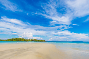 Idyllic white sand beach seascape blue sky with island