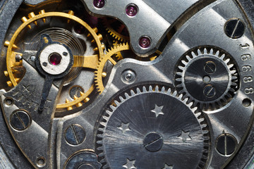 Antique wrist watch with metal gears and cogwheels. Detail of watch machinery, macro.