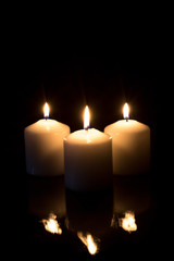 candles with reflection burning on black background with copy space